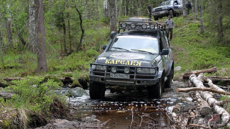 Караван джипов пересекает лесную речку в Карелии