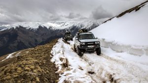Внедорожники на заснеженной горной дороге Центрального Кавказа