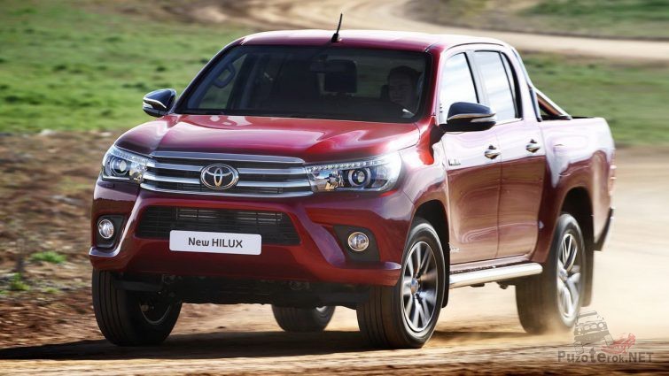 Новая красная Toyota Hilux на скорости за городом