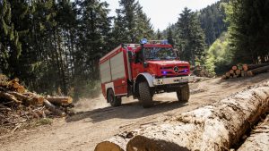 Пожарная машина на базе Унимога среди брёвен в лесу