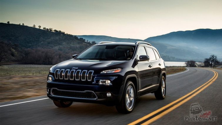 Чёрный Jeep Cherokee едет по шоссе