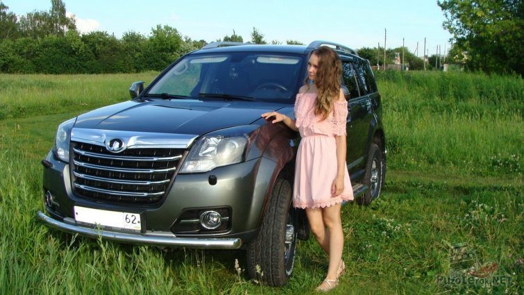 Девушка возле автомобиля на траве