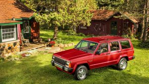 Красный Jeep Cherokee во дворе девенского дома