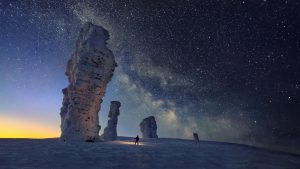 Столбы Маньпупунёр зимой на фоне звёзд