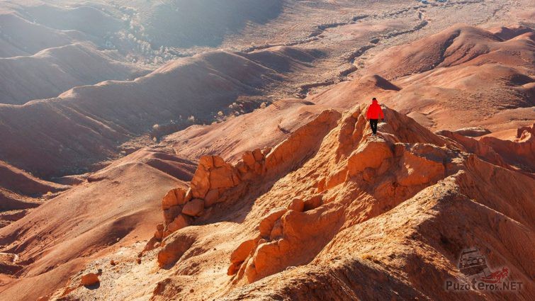 Турист в красном на вершине горы