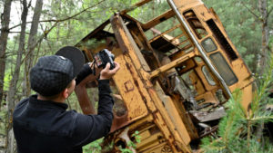 Турист фотографирует ржавый автобус в лесу