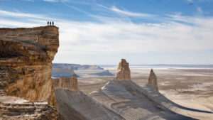 Туристы на вершине скалы над пустыней