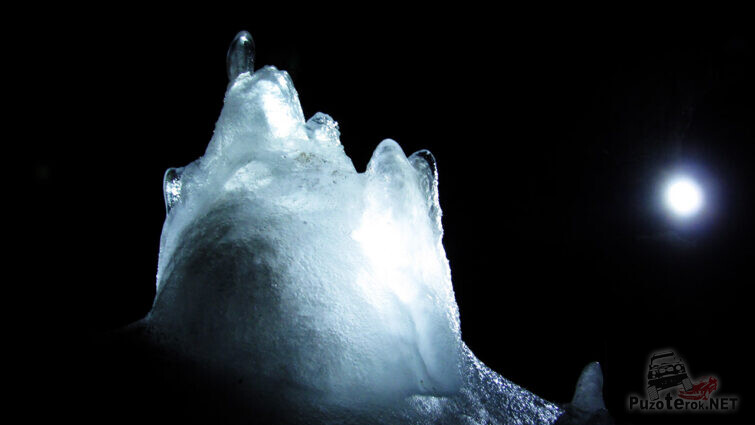 Прозрачная ледяная фигура в луче фонаря